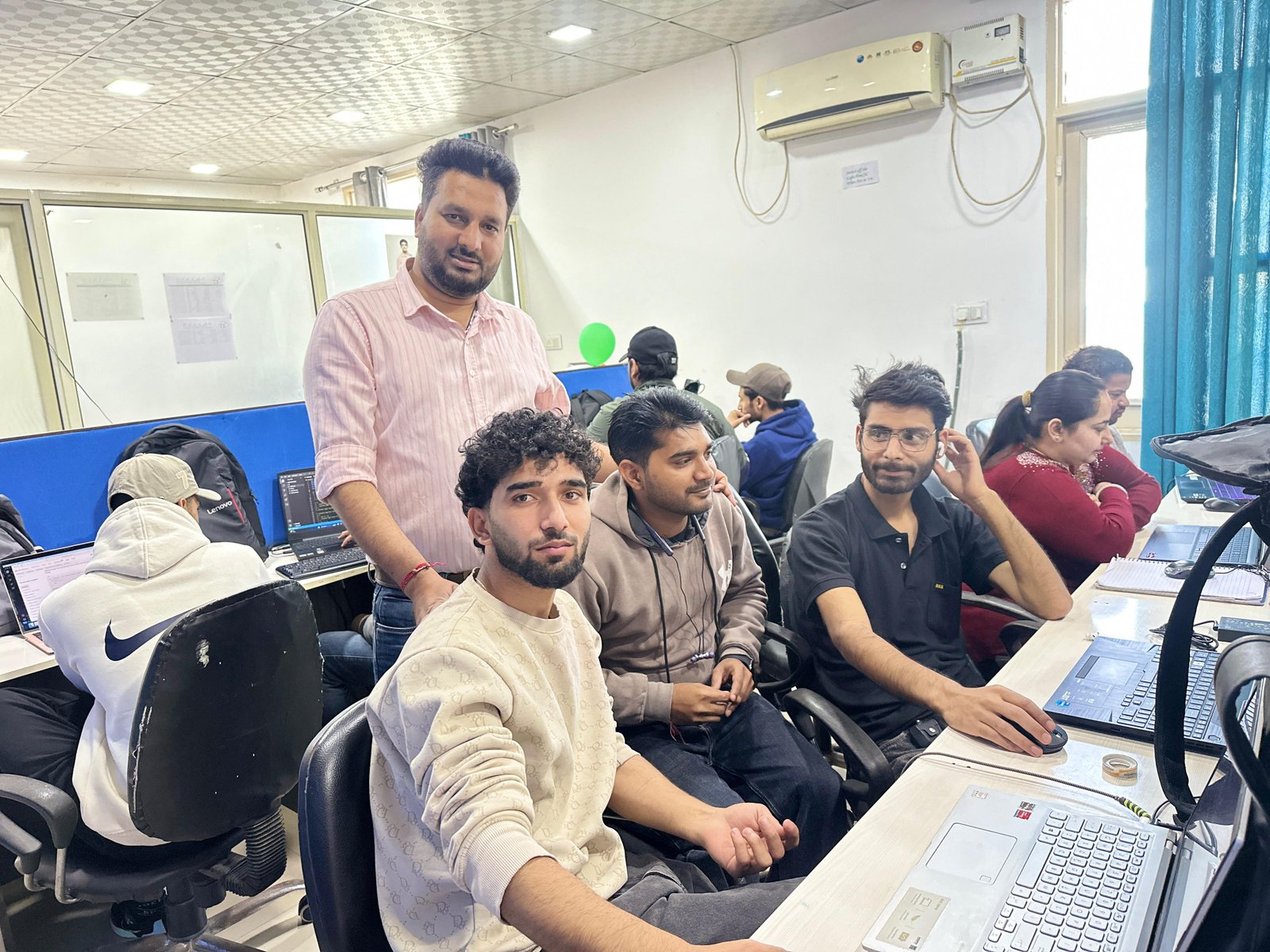 Senior mentor guiding students in SKYSYS computer design lab
